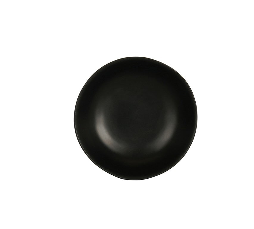 A plain, round, matte black ceramic plate with a slightly irregular edge is centered on a white background. The plate, reminiscent of a hand thrown bowl, is empty and features a modern, minimalist design.