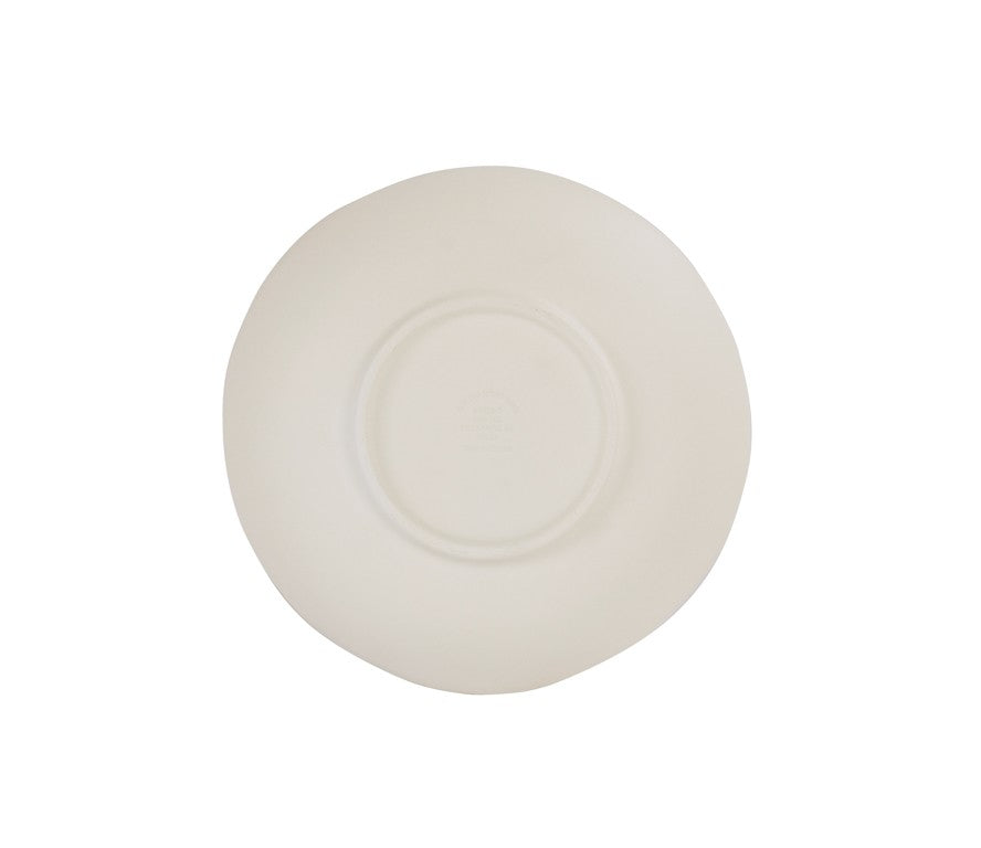 A plain, round, off-white ceramic plate with a subtly uneven, organic edge is shown from above on a white background. The plate has a small, indented circular rim near the center, highlighting its hand thrown bowl aesthetic.
