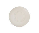A plain, round, off-white ceramic plate with a subtly uneven, organic edge is shown from above on a white background. The plate has a small, indented circular rim near the center, highlighting its hand thrown bowl aesthetic.