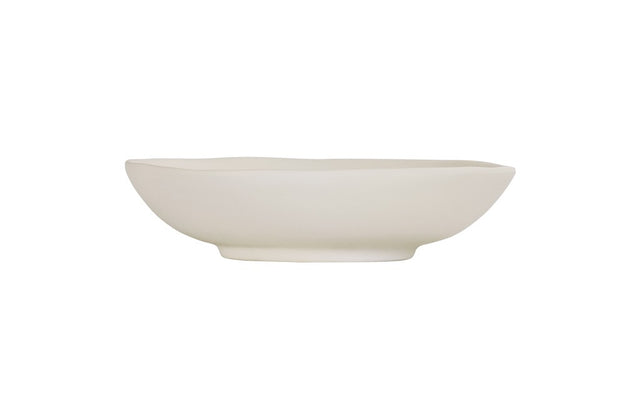 A plain, white, hand thrown bowl with smooth, gently curved sides and a slightly uneven rim sits on a white background. The minimalist, unadorned design gives this ceramic vessel a simple and modern appearance.