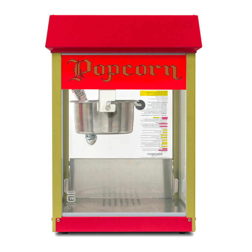 A vintage-style countertop popcorn machine with a red top, gold frame, and glass front. Above the E-Z Kleen kettle inside, "Popcorn" is written in ornate yellow and black. The interior of this popcorn popper is empty.