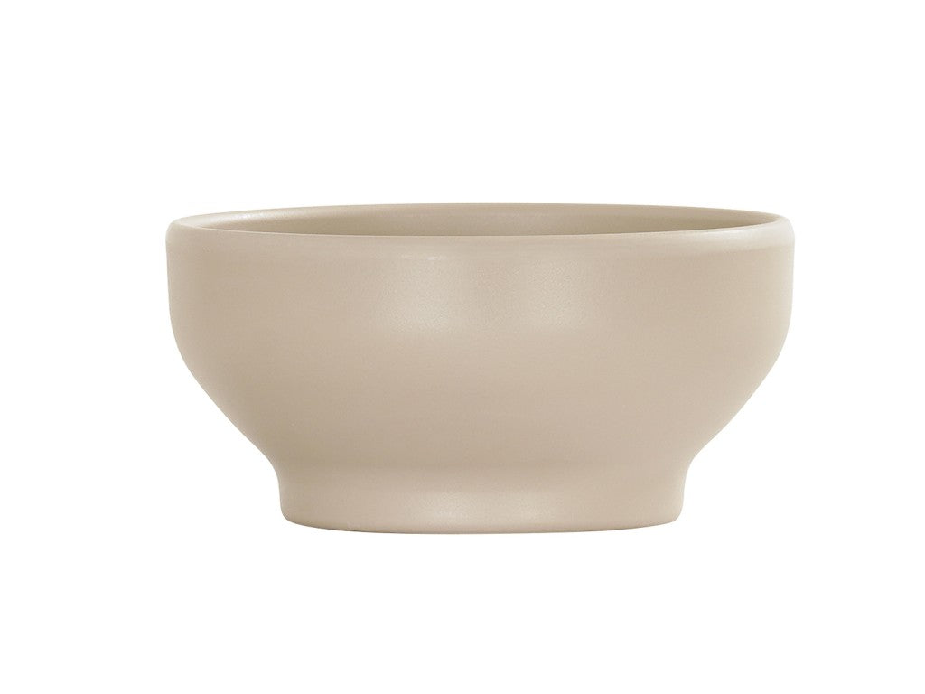 The 16 oz Nova Soup Bowl, in a simple taupe ceramic, features smooth, curved sides and a matte finish. Its wide opening, gently sloping sides, and small raised base create an elegant look on a white background.