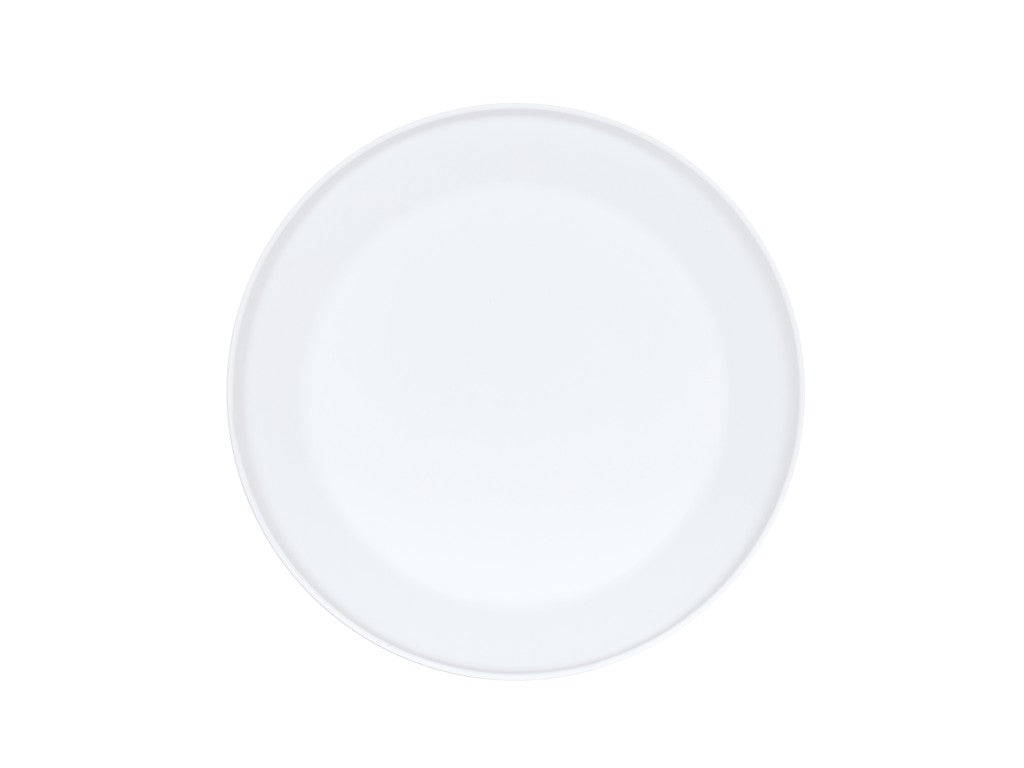 A plain, round, white ceramic plate, reminiscent of the Cal-Mil Nova Bowl, is photographed from above and centered on a white background. The smooth surface features a subtle rim with no decorations or markings.