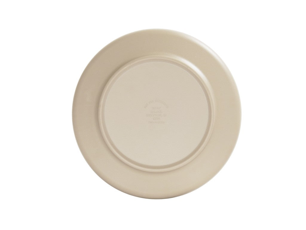 A plain, round, taupe plate is shown from above against a white background. The plate features a smooth surface and slightly raised rim around the edge. Indistinct text or branding is faintly visible in the center.