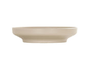 A beige, shallow, round ceramic Nova Bowl with a wide rim and flat base, photographed against a plain white background. This 9 inch bowl features smooth, clean lines and a minimalist design.