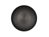 A round, black coupe bowl with a subtle concentric circular pattern radiating from the center, seen from a top-down view against a plain white background. The design creates a sense of texture and depth on the plate’s surface.