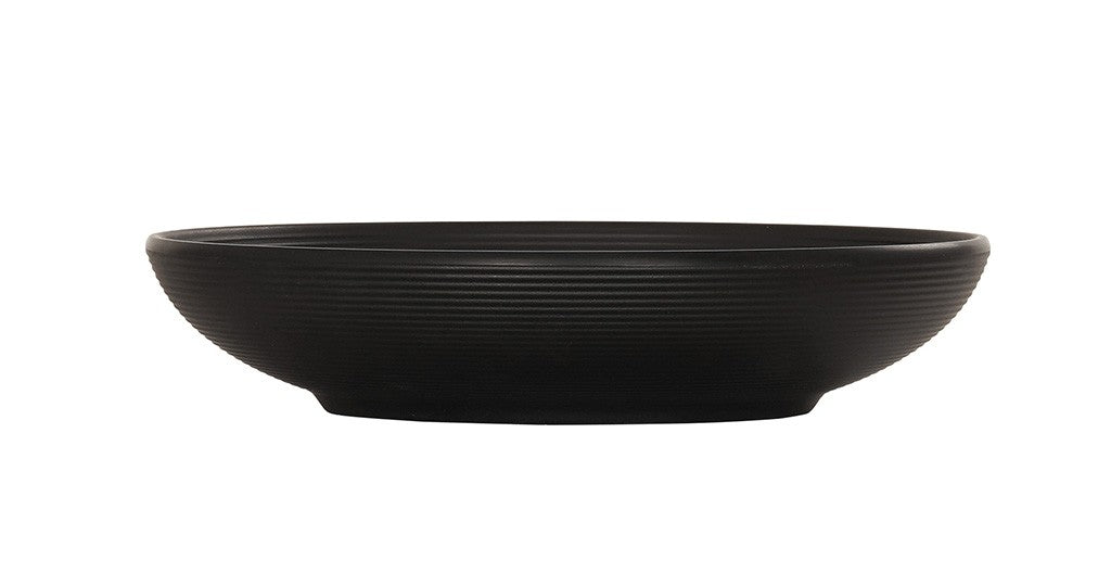 A matte black coupe bowl with a low, round shape, slightly flared rim, and fine horizontal ridges around the exterior. The Charlotte Bowl sits on a small, flat base and is photographed against a plain white background.