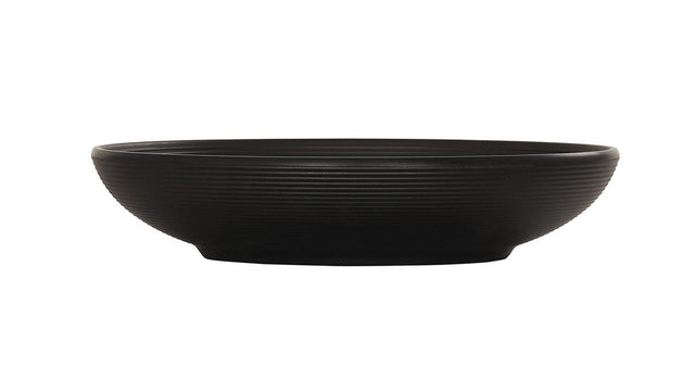 A matte black coupe bowl with a low, round shape, slightly flared rim, and fine horizontal ridges around the exterior. The Charlotte Bowl sits on a small, flat base and is photographed against a plain white background.