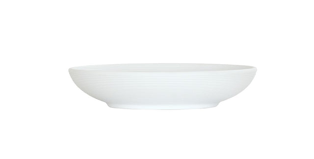A shallow, round Charlotte Bowl with a subtle horizontal ribbed texture, shown from the side on a plain white background. This white ceramic bowl has a wide opening and a small, slightly raised base.