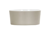 A plain, round, light beige ceramic bowl with smooth sides and a glossy white interior, shown against a white background. Minimalistic and unadorned, this dishwasher safe design is ideal for serving food or as a decorative piece.