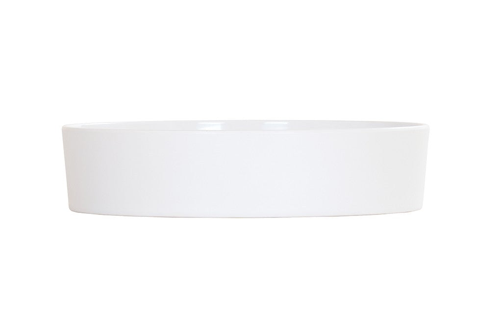 A plain, round, white ceramic dish with straight sides, shown against a white background. Dishwasher safe and easy to clean, the dish is empty and photographed from a side angle, highlighting its minimalist design and smooth surface.