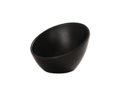 A matte black bowl with a slanted rim sits on a white background. This 5 inch round bowl features a smooth, modern surface and minimalist design, with the opening tilted at an angle for a unique, contemporary look.