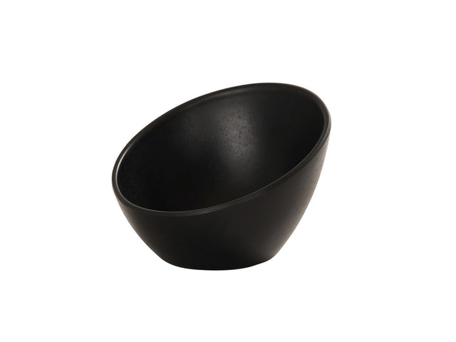 A matte black bowl with a slanted rim sits on a white background. This 5 inch round bowl features a smooth, modern surface and minimalist design, with the opening tilted at an angle for a unique, contemporary look.