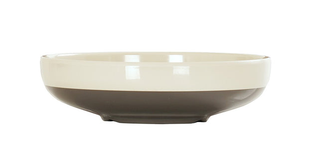 A shallow, round Vienna Bowl with a glossy finish. The upper half is cream-colored, while the lower half is a dark grayish-brown. This ceramic bowl has a smooth rim, rests on a slightly elevated base, and is set against a plain white background.