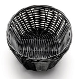 A round, empty, black polypropylene basket sits on a white surface. The hand-woven, sturdy rattan-style material has a smooth, glossy finish and a slightly flared rim. A shadow underneath suggests overhead lighting.
