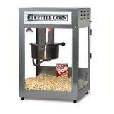 A Kettle Corn Popcorn Machine with a glass enclosure displays fresh popcorn inside. A red and white striped popcorn box sits among the popcorn, while a metal kettle is suspended in the center under a light.