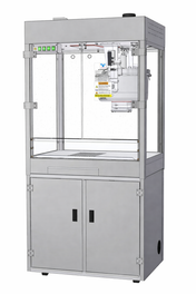 A metal industrial machine with a transparent front panel, control buttons on the top left, and a stainless steel cabinet below. Inside, the Discovery 32 oz. Popcorn Popper features a robotic arm mechanism and visible warning labels for safety.