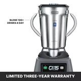A silver Waring commercial blender with two side handles and a stainless steel container sits on a black base labeled “CB15 The Legend.” A caption points to the blender, reading “Blend 100+ drinks a day.” Bold text at the bottom reads, “LIMITED THREE-YEAR WARRANTY.”.