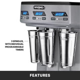 Close-up of a Waring triple spindle Drink Mixer with three stainless steel spindles and metal mixing cups, each featuring programmable digital timers and control buttons. A label highlights “3 spindles, with individual programmable timers.”.