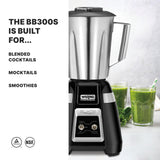 A stainless steel Bar Blender sits on a counter next to two green smoothies in glasses with straws. On the left, text reads: The BB300S is built for international use—perfect for blended cocktails, mocktails, and smoothies. NSF certification logos at bottom left.