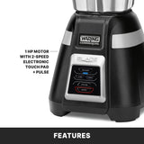 Close-up of a black Waring Commercial Blade Bar Blender base with four electronic touchpad controls labeled LOW, HIGH, PULSE, and STOP. Text highlights “1 HP MOTOR WITH 2-SPEED ELECTRONIC TOUCH PAD + PULSE.” Bottom banner reads “FEATURES.”.