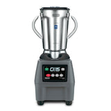 A heavy-duty food blender, the Waring CB15 features a stainless steel jug with two side handles, a black base, labeled buttons in green, red, and black, a digital screen, and “CB15 The Legend” text on the front panel.