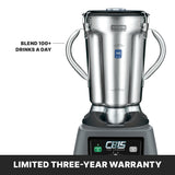 A commercial blender with a stainless steel container, two side handles, and a digital control panel. Text reads “Blend 100+ drinks a day.” Bottom banner: “Limited three-year warranty.” The brand logo “CB15 THE LEGEND” is visible on the front.