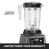 A 1 gallon blender with a clear container showing measurements, marked “Blend 100+ drinks a day.” The base has a digital display labeled “CB15 The Legend.” A banner below reads “LIMITED THREE-YEAR WARRANTY” in bold white text on black.
