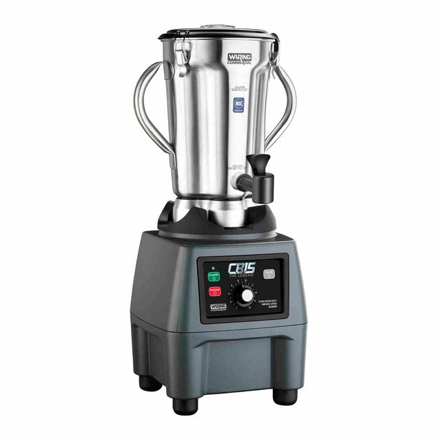 A 4 liter commercial blender with a stainless steel container and two side handles sits on a sturdy black base. The base features buttons, switches, and a dial labeled with various settings. The lid displays a warning label.