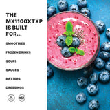 A vibrant pink smoothie topped with blueberries, chia seeds, and mint sits on a blue surface surrounded by scattered blueberries. Bold text lists uses for the BPA Free Blender MX1100XTXP: smoothies, frozen drinks, soups, sauces, batters, and dressings.