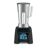 A heavy duty commercial blender with a tall stainless steel container, clear lid, and side handle sits on a black base. The digital control panel is labeled "Xtreme" and "Waring Commercial." The background is plain white.