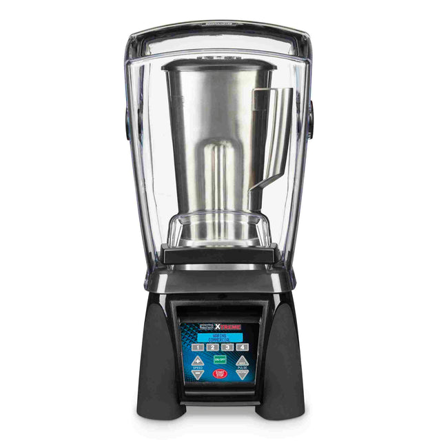 A commercial high-power blender with a clear sound enclosure, a digital control panel with blue accents and buttons, and a large stainless steel container inside the enclosure. The blender features a sturdy black base.