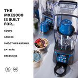 A professional programmable blender with a clear lid sits on a counter next to smoothie bowls topped with fruit and seeds, drinks, and ingredients. Text reads: “THE MXE2000 IS BUILT FOR... SOUPS, SAUCES, SMOOTHIES & BOWLS, BATTERS, DRESSINGS.”.