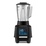 A commercial bar blender with a large stainless steel container, two spouts, and a sturdy black countertop base featuring a digital control panel, display screen, and the “Waring” brand name on a metallic plate at the front.