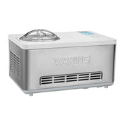 A stainless steel Waring Ice Cream Maker with a built-in compressor, clear plastic lid, side air vents, and digital control panel. This 2 qt. capacity appliance features WARING embossed on the front and stands on small feet.
