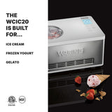 A silver Waring Ice Cream Maker with a built-in compressor sits on a black surface next to a waffle cone filled with strawberry ice cream, strawberries, and mint. Text highlights its 2 qt. capacity: "The WCIC20 is built for... Ice cream, frozen yogurt, gelato.