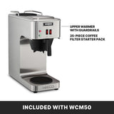 A stainless steel pourover coffee brewer with a top and bottom self regulating warmers, labeled features, and two red switches. Text highlights “Upper Warmer with Guardrails” and “25-piece Coffee Filter Starter Pack.” Banner below reads “Included with WCM50.”.