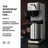 A stainless steel Waring Airpot Coffee Brewer with an open filter basket sits on a dark counter. Steam rises from a blue mug nearby. Text beside it highlights its use in offices, schools, and cafés for fresh brewed coffee and hot water on demand.