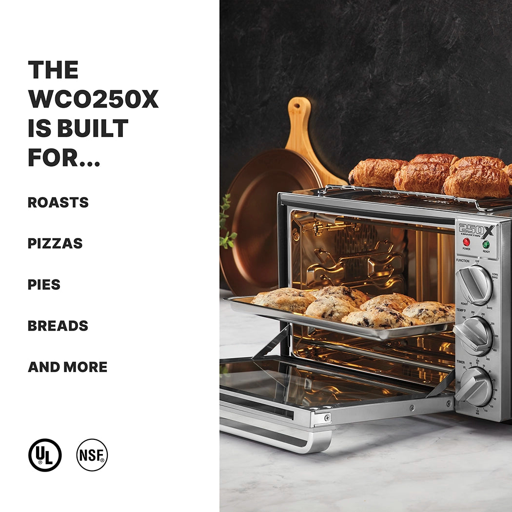 A stainless steel commercial convection oven with breads and pastries inside and on top sits on a marble counter. Next to it, a copper pan hangs on a black backsplash. Text reads: The WCO250X is built for roasts, pizzas, pies, breads and more. UL and NSF logos below.