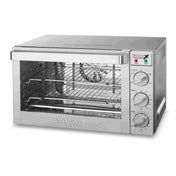 A stainless steel Commercial Convection Oven with a glass door, three control dials for function, temperature, and timer on the right side, indicator lights above the dials, and two wire racks inside. The Waring brand appears on the front.