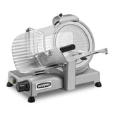 A silver electric food slicer with a circular blade, clear plastic guard, adjustable slice thickness dial, and “WARING” label on the front sits on four black rubber feet for stability against a white background.