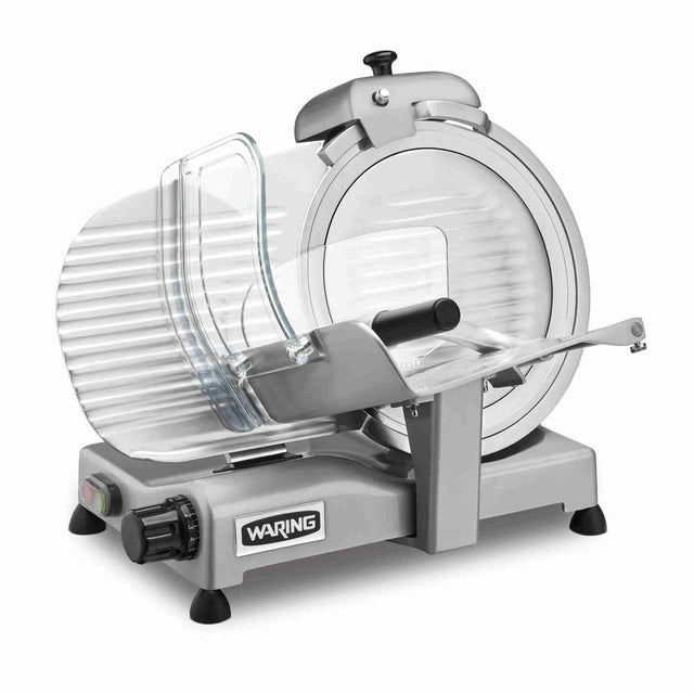 A silver Waring Commercial Food Slicer with a heavy duty 12" tempered chrome blade, clear plastic guard, thickness adjustment knob, and a metal food carriage on a sturdy gray base with non-slip feet. Clean and set against a white background.