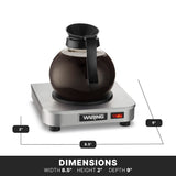 A glass coffee pot filled with coffee sits on a compact, stainless steel Waring coffee warmer. This single burner measures 8.5" wide, 2" high, and 9" deep, with a power button and indicator light conveniently on the front.