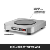 A stainless steel Waring single burner hot plate with a round heating surface, labeled “durable wipe-clean stainless steel construction.” Four nonskid feet provide stability. A red power switch is visible on the front. Text reads: “INCLUDED WITH WCW10.”.