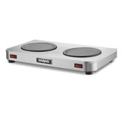 A stainless steel Waring double burner hot plate with two round heating elements, ideal as a coffee warmer, red power switches on each side, four black feet, and a central Waring logo on the smooth, modern front.
