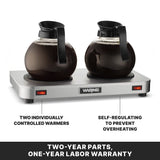 Two glass coffee decanters filled with coffee sit on a stainless steel Waring coffee warmer featuring double burner plates. Labels highlight two individually controlled warmers on the left and self-regulating to prevent overheating on the right. Warranty text below.