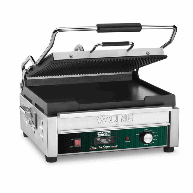 A stainless steel electric panini grill with a ridged top plate, flat bottom plate, black handle, and green control panel labeled “Tostato Supremo.” The open Dual Surface Panini Grill features adjustable thermostats and a programmable on/off dial.