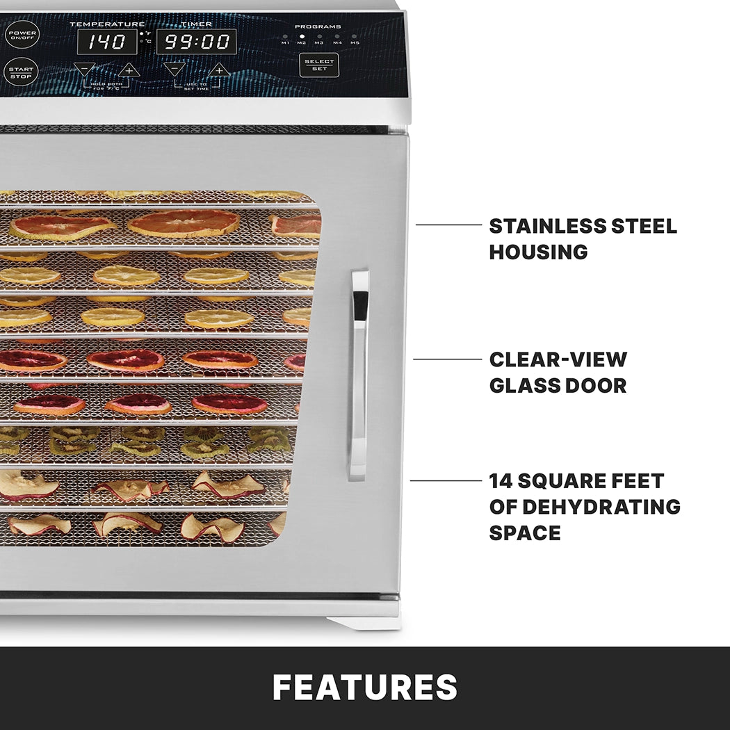 A stainless steel dehydrator with a clear-view glass door reveals multiple trays of sliced fruits and vegetables. Features include stainless steel housing, adjustable temperature, 14 square feet of space, and a digital LED display.