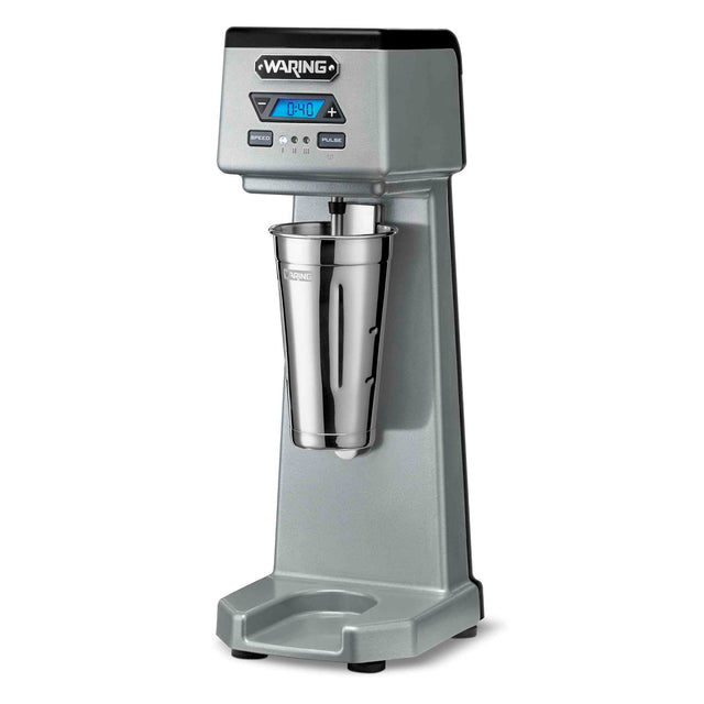 A silver heavy-duty drink mixer with a digital timer display, control buttons, and a stainless steel mixing cup. This single-spindle drink mixer stands upright with a sturdy base and sleek finish, perfect for blending milkshakes or smoothies.