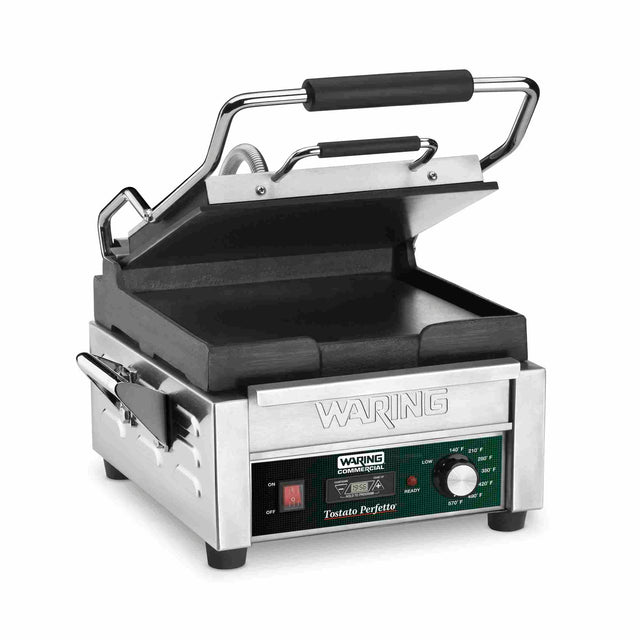 A compact toasting grill, this stainless steel Waring commercial sandwich press features flat cast iron plates, a black handle, control panel with green and red lights, adjustable thermostats, and "Tostato Perfetto" labeling.